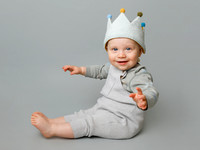 One year old boy wearing a birthday crown in a photo studio