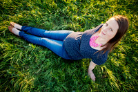 Pregnant mother photographed from above seated in the grass