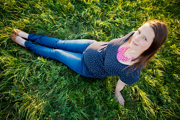 Pregnant mother photographed from above seated in the grass