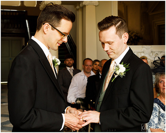 Two grooms exchange rings on their wedding day