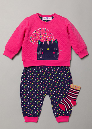 A baby wear outfit laid out flat on a grey studio backdrop