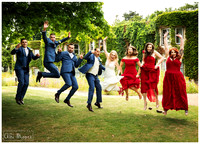 Bridal party jump during relaxed wedding photos at Oakley Court Windsor