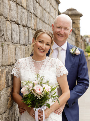A wedding couple stand by the walls of Windsor Castle