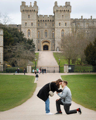 A young man proposes on one knee on Windsor's Long Walk