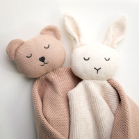 Two knitted animal toys wrapped as though they are hugging
