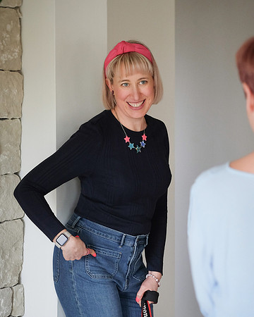 Abi on a brand photoshoot, she is looking at her client and pointing to her own hip showing her how to pose