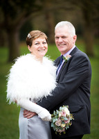 A wedding couple smile at the camera on Windsor's Long Walk