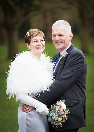 A wedding couple smile at the camera on Windsor's Long Walk