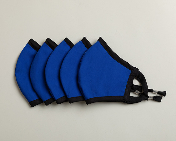Five blue face masks lined up photographed on a studio backdrop