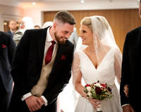 A bride and groom share a special moment during their wedding ceremony at Oakley Court