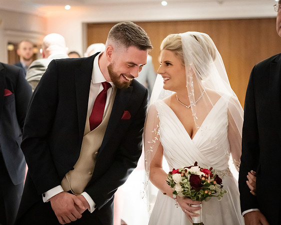 A bride and groom share a special moment during their wedding ceremony at Oakley Court