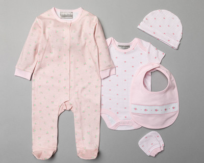 Babywear gift set photographed as a flatlay on a grey studio background