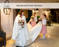 A bride looks at her bridesmaids carrying her train in the foyer of the Macdonald Windsor