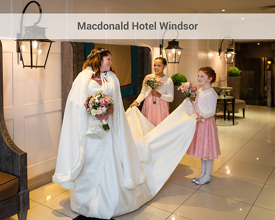 A bride looks at her bridesmaids carrying her train in the foyer of the Macdonald Windsor