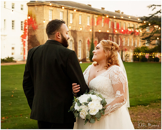 Bride & Groom smile at each other with Beaumont Estate in the background