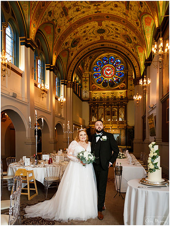 A couple stand in the chapel at Beaumont Estate Old Windsor, beautiful stained glass window in the background