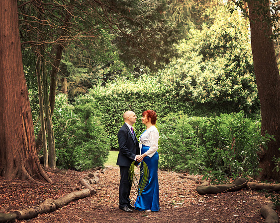 A wedding couple smile at each other surrounded by the woodland at the Berystede in Ascot