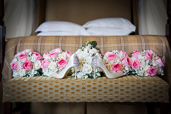 Bridal shoes and bouquets photographed on a chaise in the Berystede's bridal suite