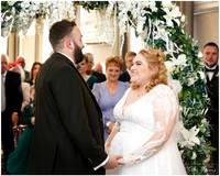 A bride and groom smile at each other during their wedding ceremony at De Vere Beaumont Estate Old Windsor
