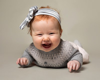 Cute baby girl lying on front with huge smile