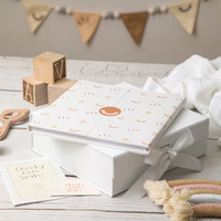 Branding photoshoot image of a baby journal stacked with gift box and baby items