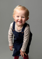 A toddler girl creases over laughing
