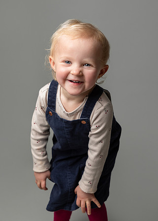 A toddler girl creases over laughing