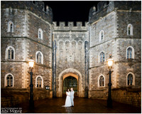 A couple stand at the foot of a floodlit Windsor Castle