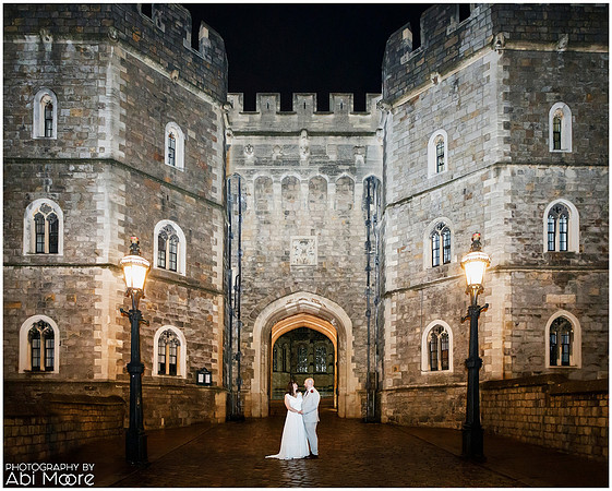 A couple stand at the foot of a floodlit Windsor Castle