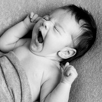 Baby photographed on a professional newborn shoot in black & white, baby yawning