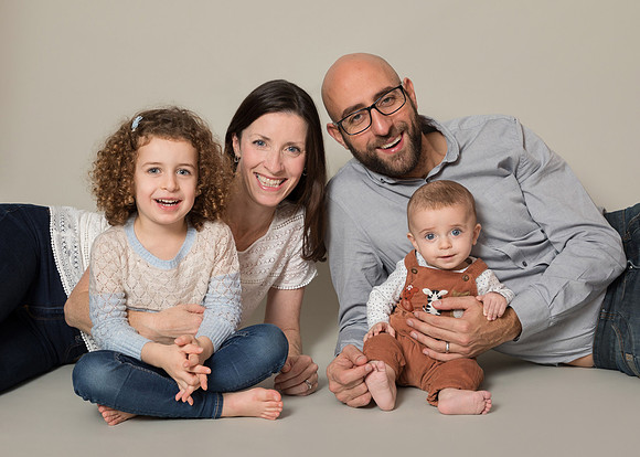 Family with daughter and baby son photographed in relaxed studio setting