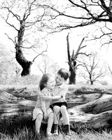 Brother and sister giggle together during outdoor professional photoshoot