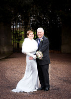 A full-length photo wedding couple smiling at the camera on Windsor's Long Walk