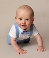 Baby smiles and crawls towards camera in studio photoshoot