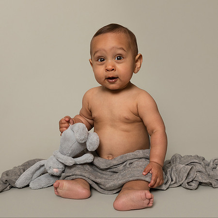 nine month old baby with grey blanket and bunny