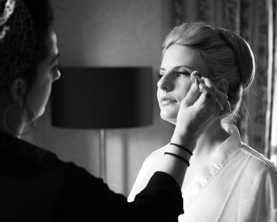 bride photographed in beautiful light having her make up finished for her wedding