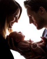 Parents in silhouette with their newborn baby