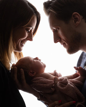 Parents in silhouette with their newborn baby