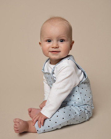 studio photo of baby boy in blue outfit
