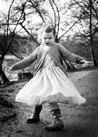 A young girl twirls her skirt by the lake at Black Park in Slough