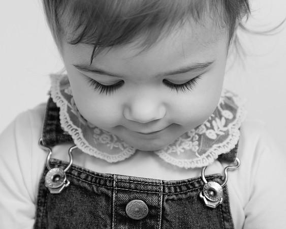 Close-up photo of todler girl with lace collar and beautiful long dark lashes