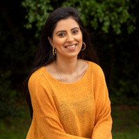 Woman smiles at camera in a relaxed outdoor setting