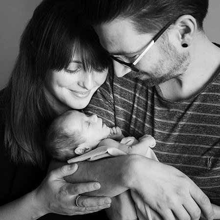 Close-up photo of mum & dad looking down at their newborn daughter