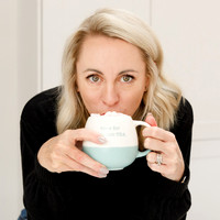 Lady leaning forward drinking coffee looking directly at the camera