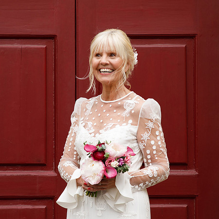 A close-up of a bride laughing by Windsor Guildhall’s red doors
