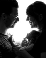 Parents with newborn baby photographed in semi-silhouette, backlit by a studio flash