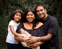Newborn baby cradled in his mother's arms with father and sister eitherside, photographed outdoors