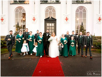 "A bridal party of seven groomsmen, five bridesmaids, flower girls and page boy walk together girl-boy-girl-boy outside the White House at Windsor's Beaumont Estate