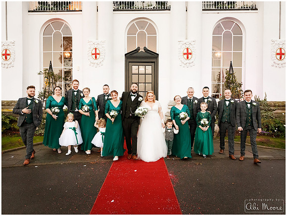 "A bridal party of seven groomsmen, five bridesmaids, flower girls and page boy walk together girl-boy-girl-boy outside the White House at Windsor's Beaumont Estate