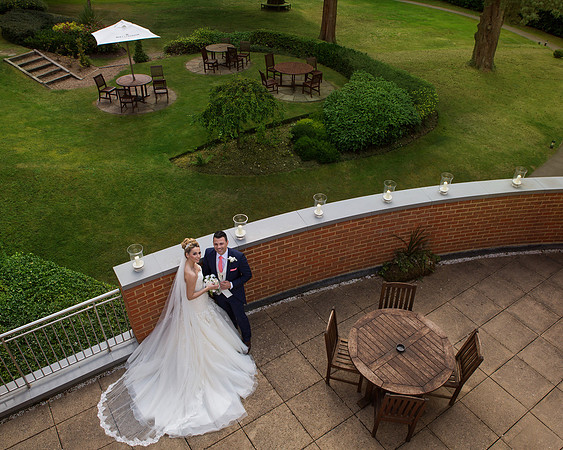 A bride and groom are photographed from above on the balcony of Macdonald Berystede Ascot